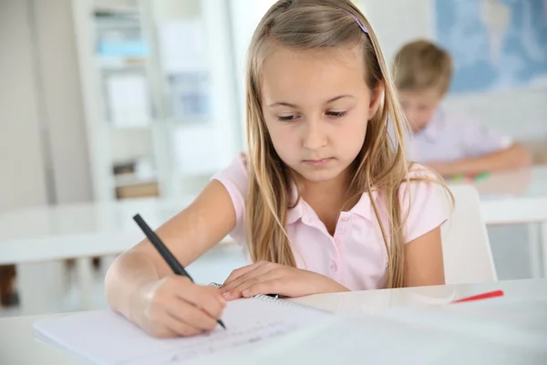 Colegiala escribiendo en cuaderno — Foto de Stock