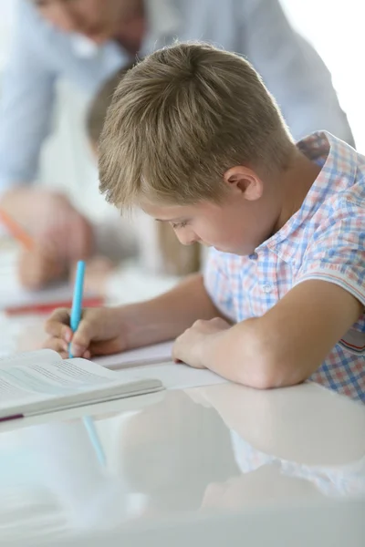 Colegial escribiendo en cuaderno — Foto de Stock