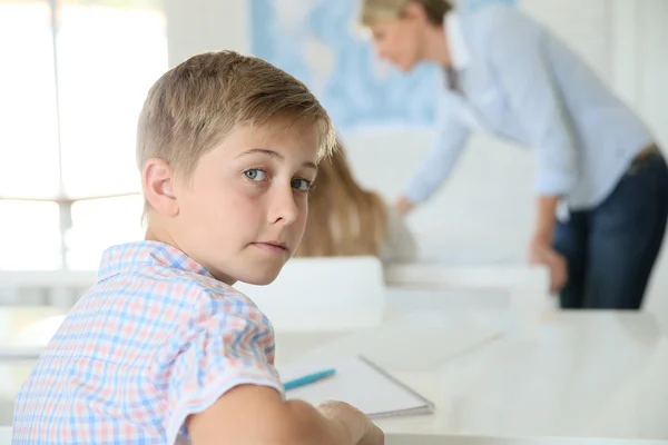 Smiling schoolboy in classroom — Stock Photo, Image