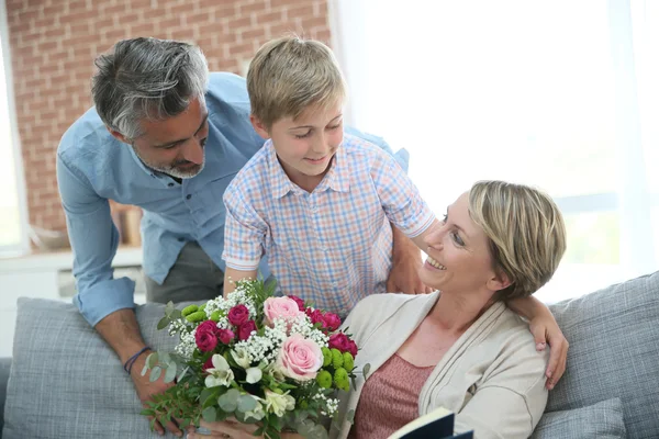Garçon donnant des fleurs à maman — Photo
