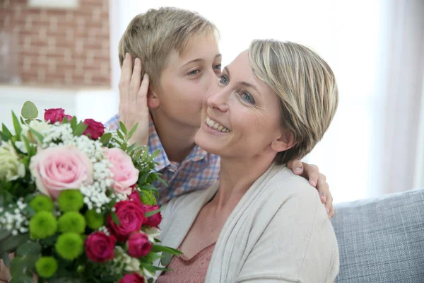 Menino dando flores para mamãe — Fotografia de Stock