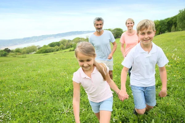 Familia corriendo en el campo — Foto de Stock