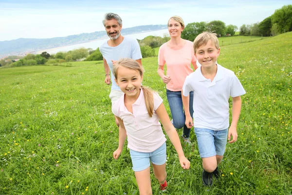 Família correndo no campo — Fotografia de Stock