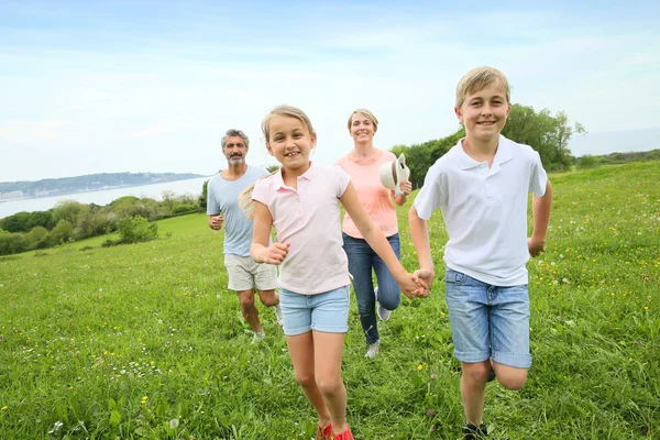 Família correndo no campo — Fotografia de Stock