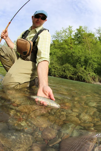 Fisherman catching brown trout — Stock Photo, Image