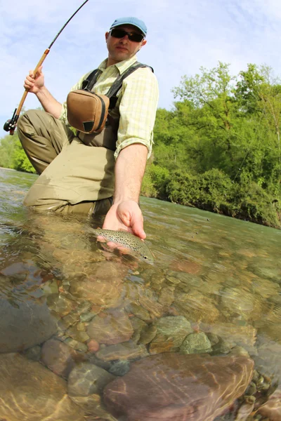 Pêcheur attrapant la truite brune — Photo