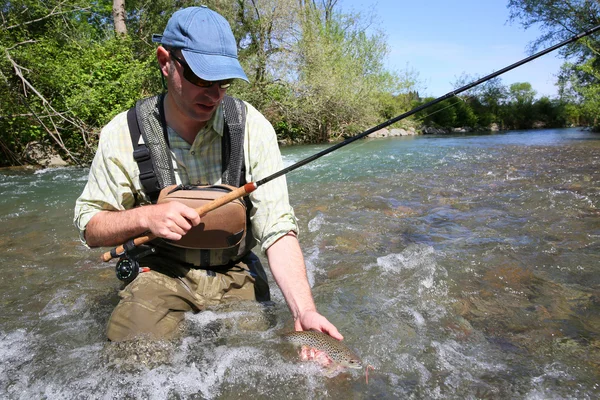 Pêcheur attrapant la truite brune — Photo