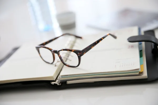 Eyeglasses on business agenda — Stock Photo, Image