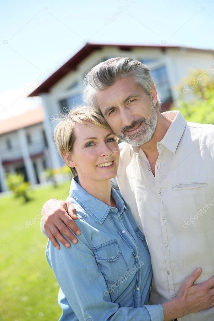 Couple standing in front of house