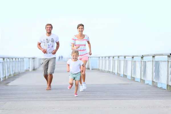 Le menina com os pais correndo — Fotografia de Stock