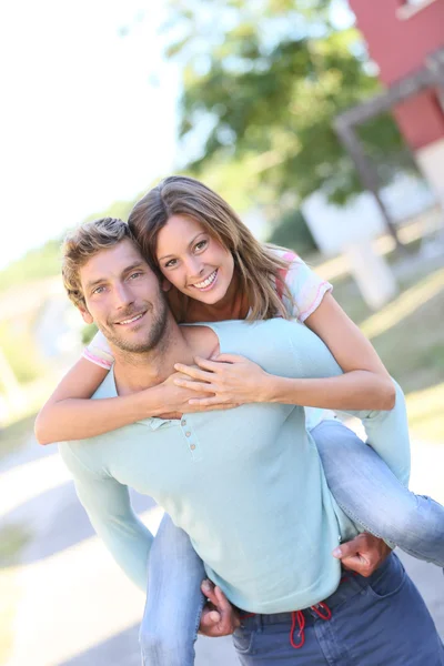 Man giving piggyback ride to woman — Stock Photo, Image