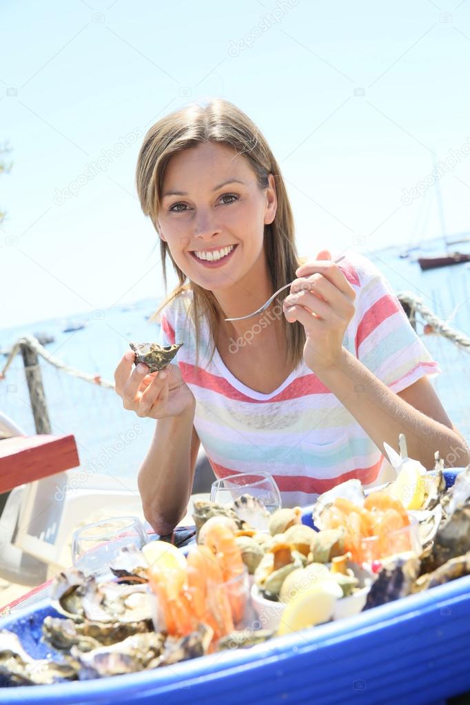 woman tasting fresh oysters