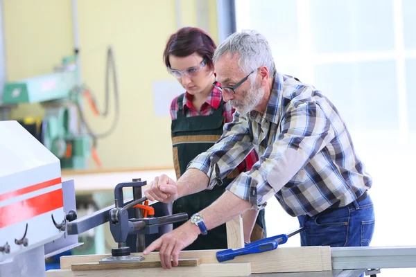 Carpenter showing  how to use sawing machine — Stock Photo, Image