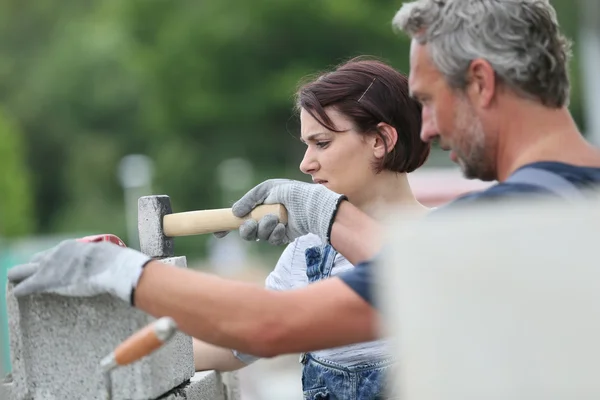 Muratore con muro di costruzione tirocinante — Foto Stock