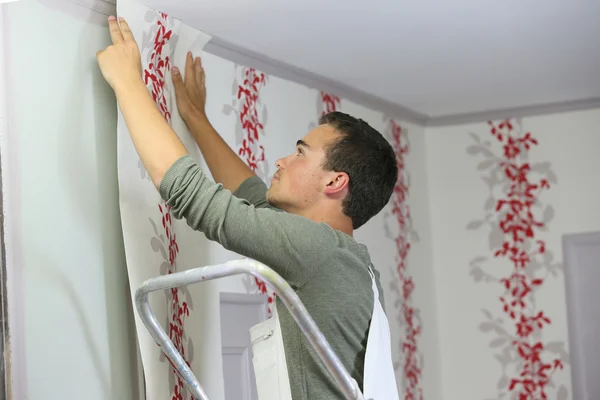 Apprentice learning how to put wallpaper — Stock Photo, Image