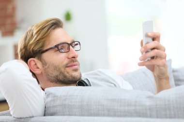 Adam rahatlatıcı kanepe ile smartphone