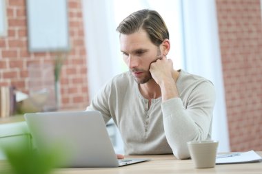 dizüstü bilgisayar başında oturan adam 