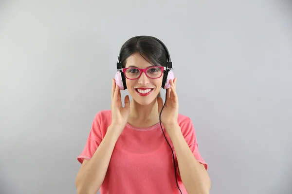 Girl with eyeglasses on using headphones — Stock Photo, Image