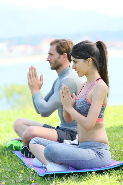 Meditasyon ve yoga egzersizleri yapıyor Çift — Stok fotoğraf