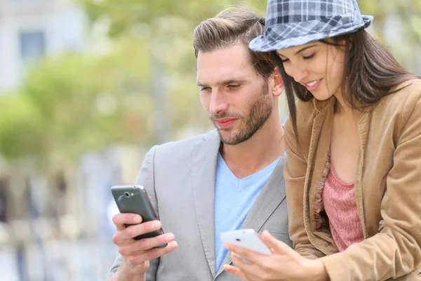 Ouple in town using smartphone — Stock Photo, Image