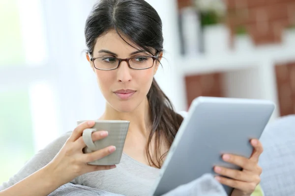 Girl relaxing in sofa connected on tablet — Stock Photo, Image