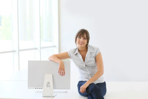 Mulher sentada na mesa por computador — Fotografia de Stock