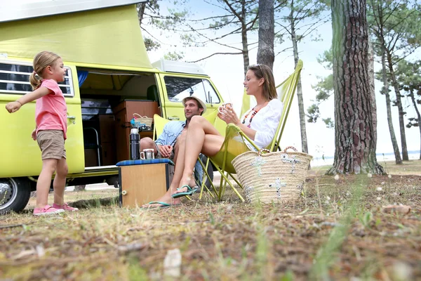 happy family relaxing by camper van