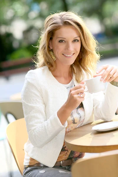 Femme assise à table et buvant du thé — Photo