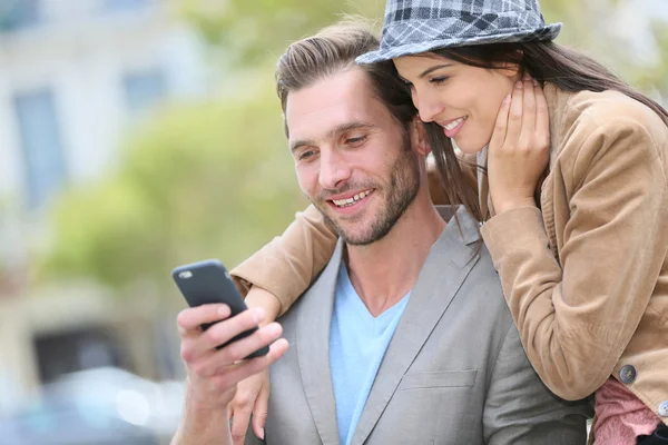 Paar in de stad gebruikend smartphone — Stockfoto