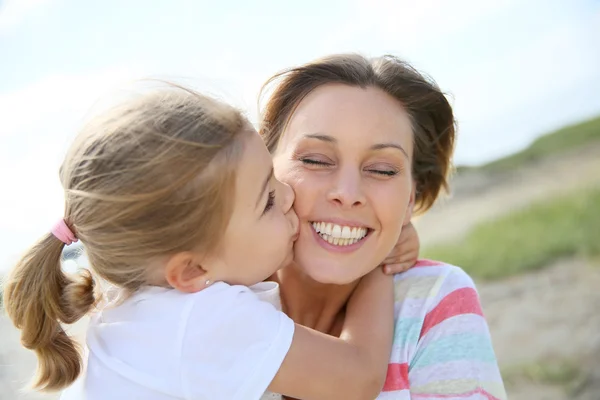 Kleines Mädchen küsst ihre Mutter — Stockfoto