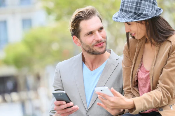 Ouple in town using smartphone — Stock Photo, Image
