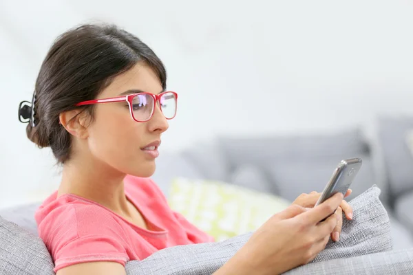 Mädchen mit roter Brille beim Lesen von Nachrichten — Stockfoto