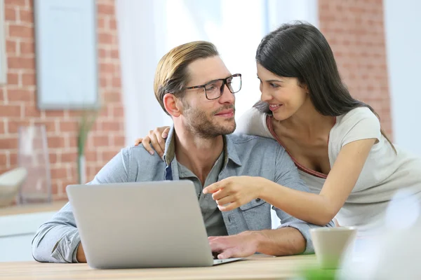 Couple at home websurfing on laptop — Stock Photo, Image