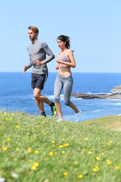 Runners exercising by cliff — Stock Photo, Image
