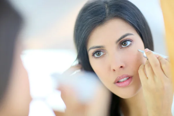 Vrouw met behulp van cosmetica — Stockfoto