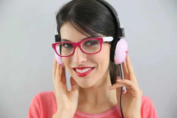 Girl with eyeglasses on using headphones — Stock Photo, Image