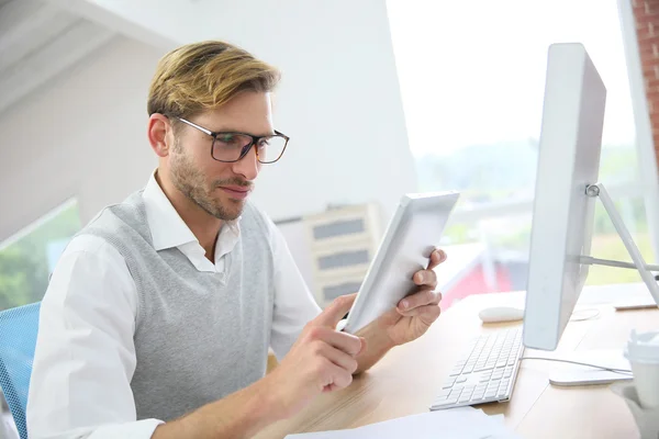 Homem no escritório trabalhando em tablet digital — Fotografia de Stock