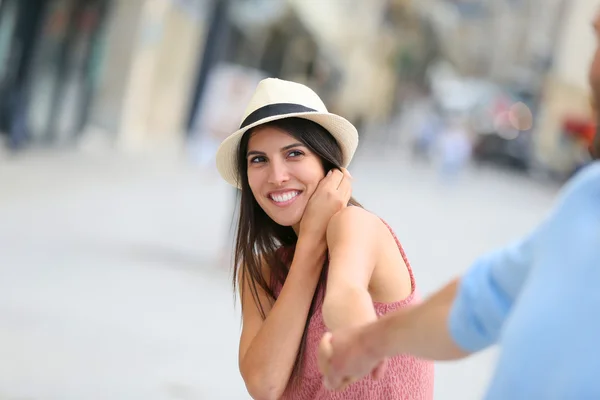 Girl with hat holding boyfriend 's hand — стоковое фото