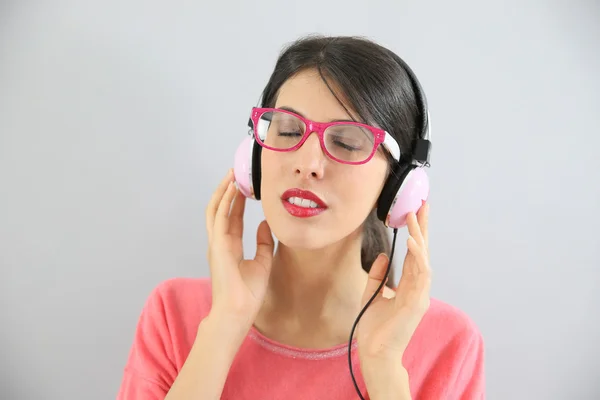 Ragazza con gli occhiali utilizzando cuffie — Foto Stock