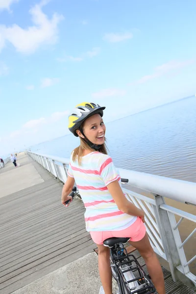 Woman riding bike on a pontoon — Stock Photo, Image