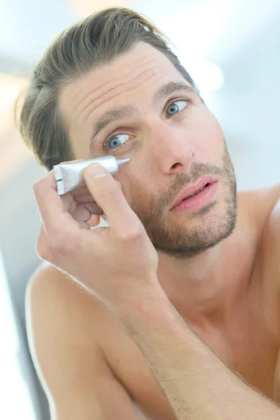 Man met cosmetische crème — Stockfoto