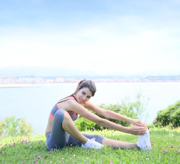 Женщина делает упражнения на растяжку снаружи — стоковое фото