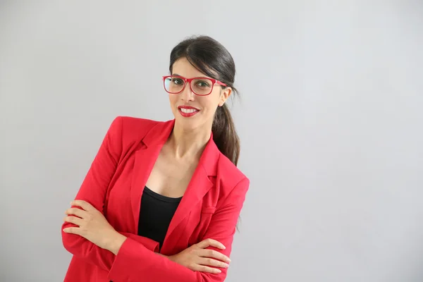 Lány piros kabátot és szemüveg pózol — Stock Fotó