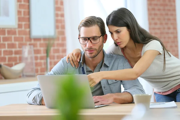 Pareja en casa websurf en el ordenador portátil —  Fotos de Stock