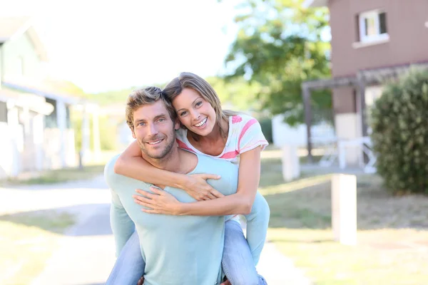 Man geven piggyback rit naar vrouw — Stockfoto