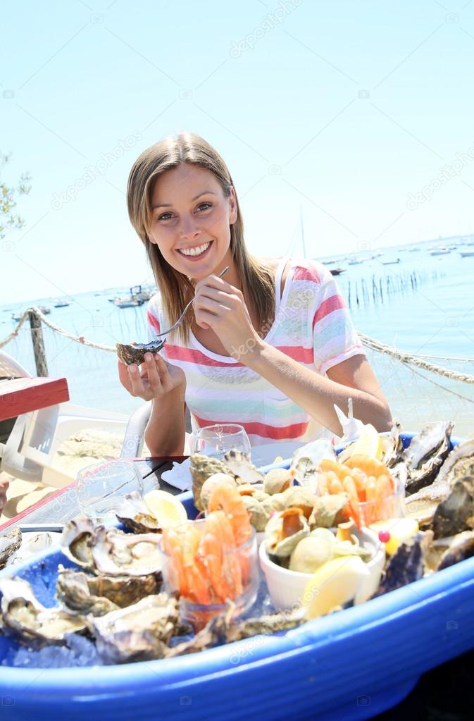 woman tasting fresh oysters