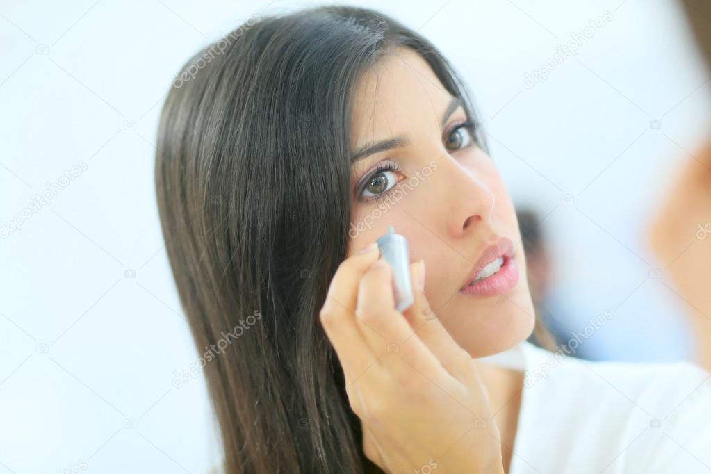 woman applying concealer