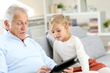 Büyükbaba dijital tablet ile oynayan kızla