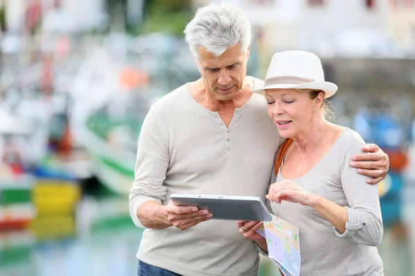 Pareja mirando la tableta mientras visita la ciudad — Foto de Stock