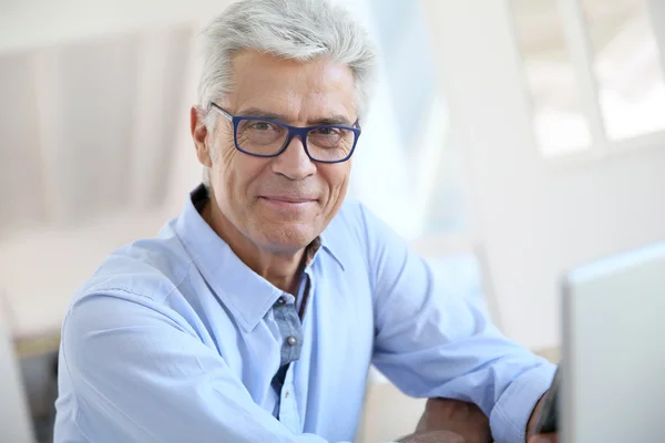 Man connected on computer smiling — Stock Photo, Image
